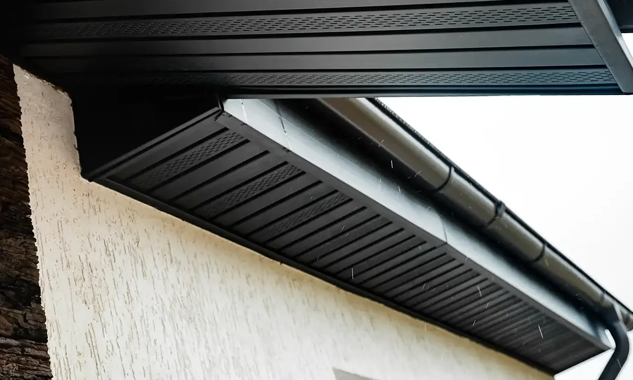Close-up of modern black vented soffit panels installed on a residential roofline