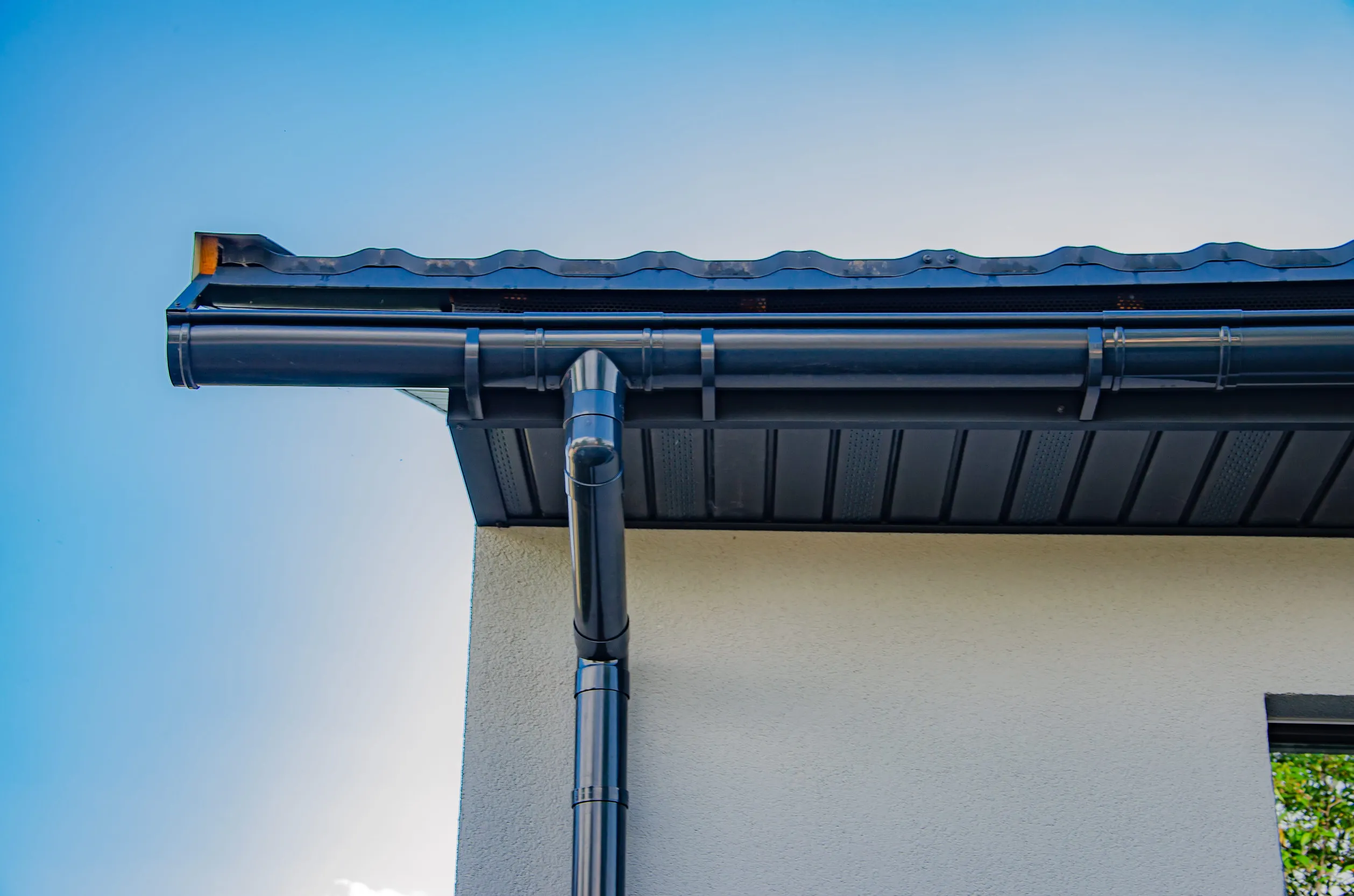 Gutter with downpipe on the roof of a house